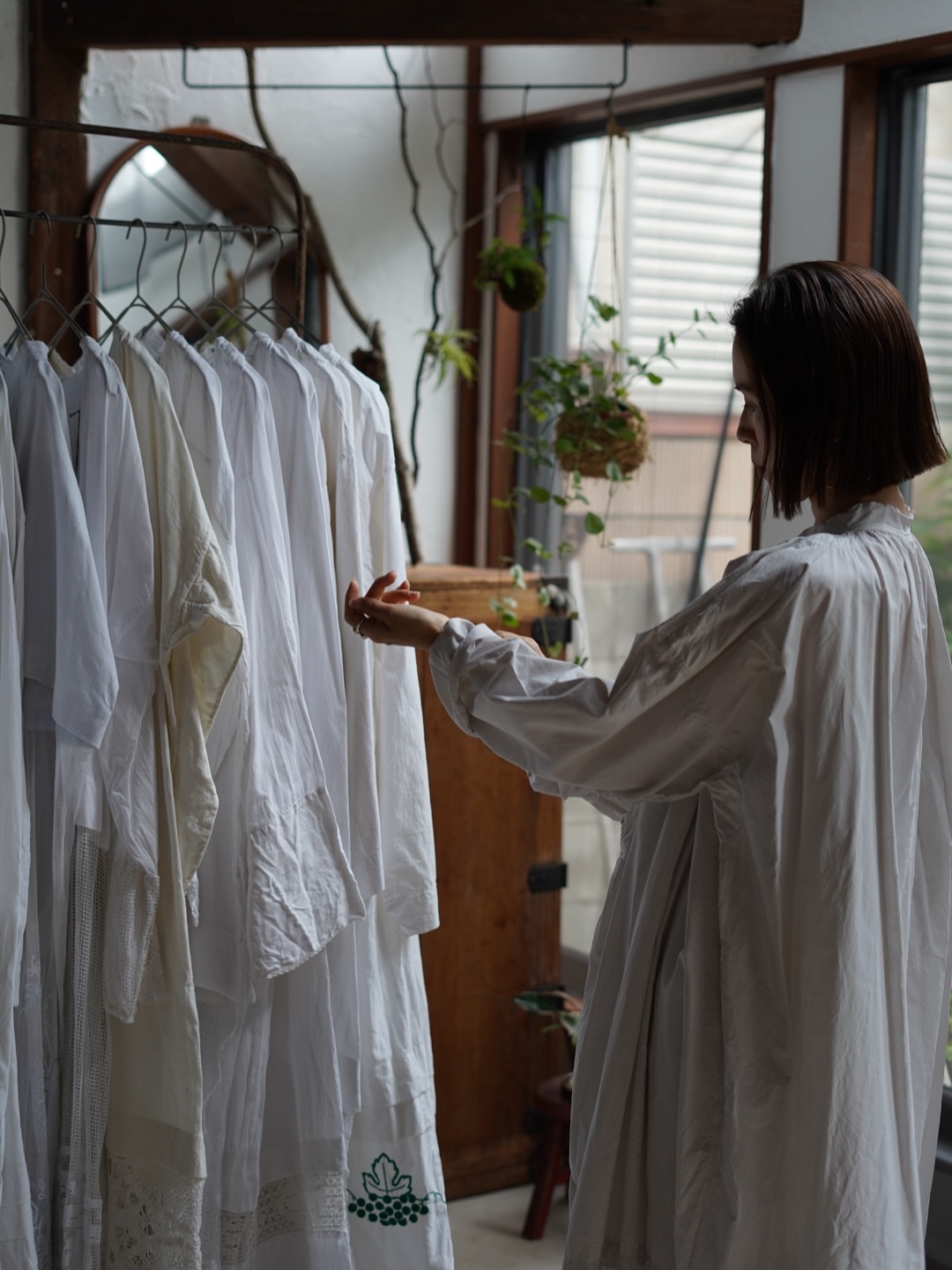 白い服が並ぶ空間で、暮らしの中から専門店の世界観を選び取る女性